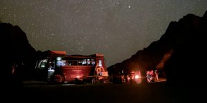 African Overland Tours truck and campfire at night in desert