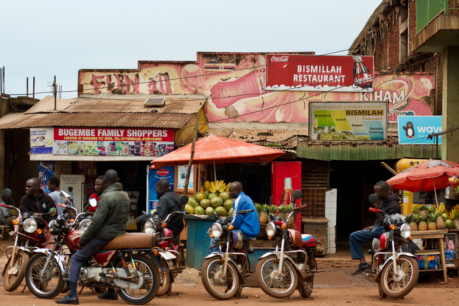 Motorcyclists and local spaza shops in Jinja, Uganda