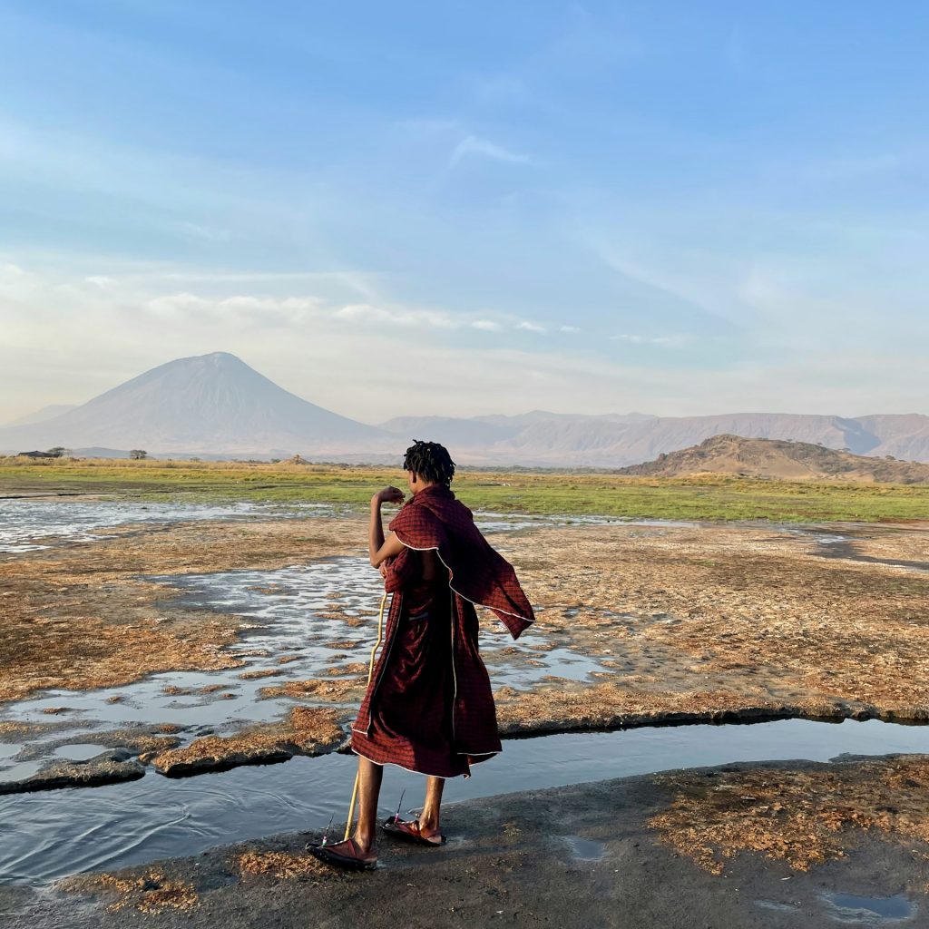 Man walking with Ol Doinyo Lengai in bacground, Great Rift Valley of Africa
