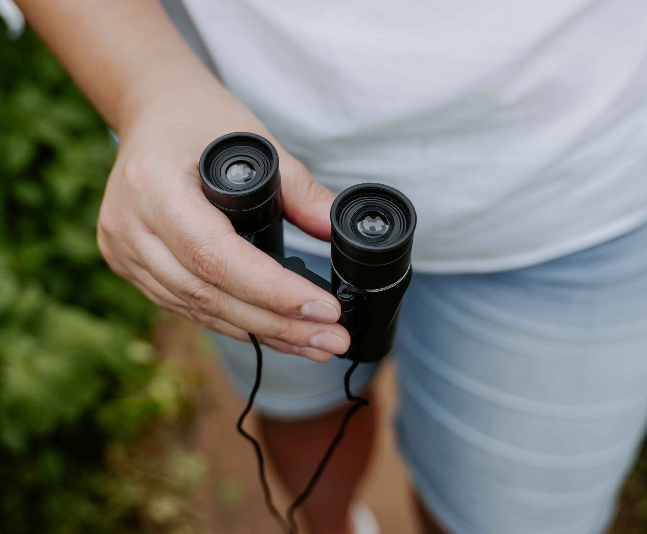 Man holding binoculars in hand, close up