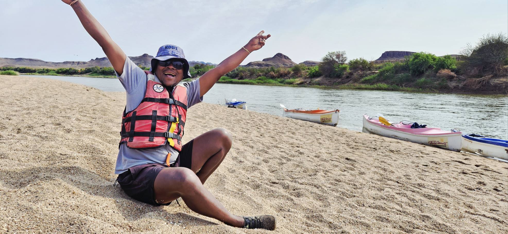 Orange River rafting, man seated on sandy shore