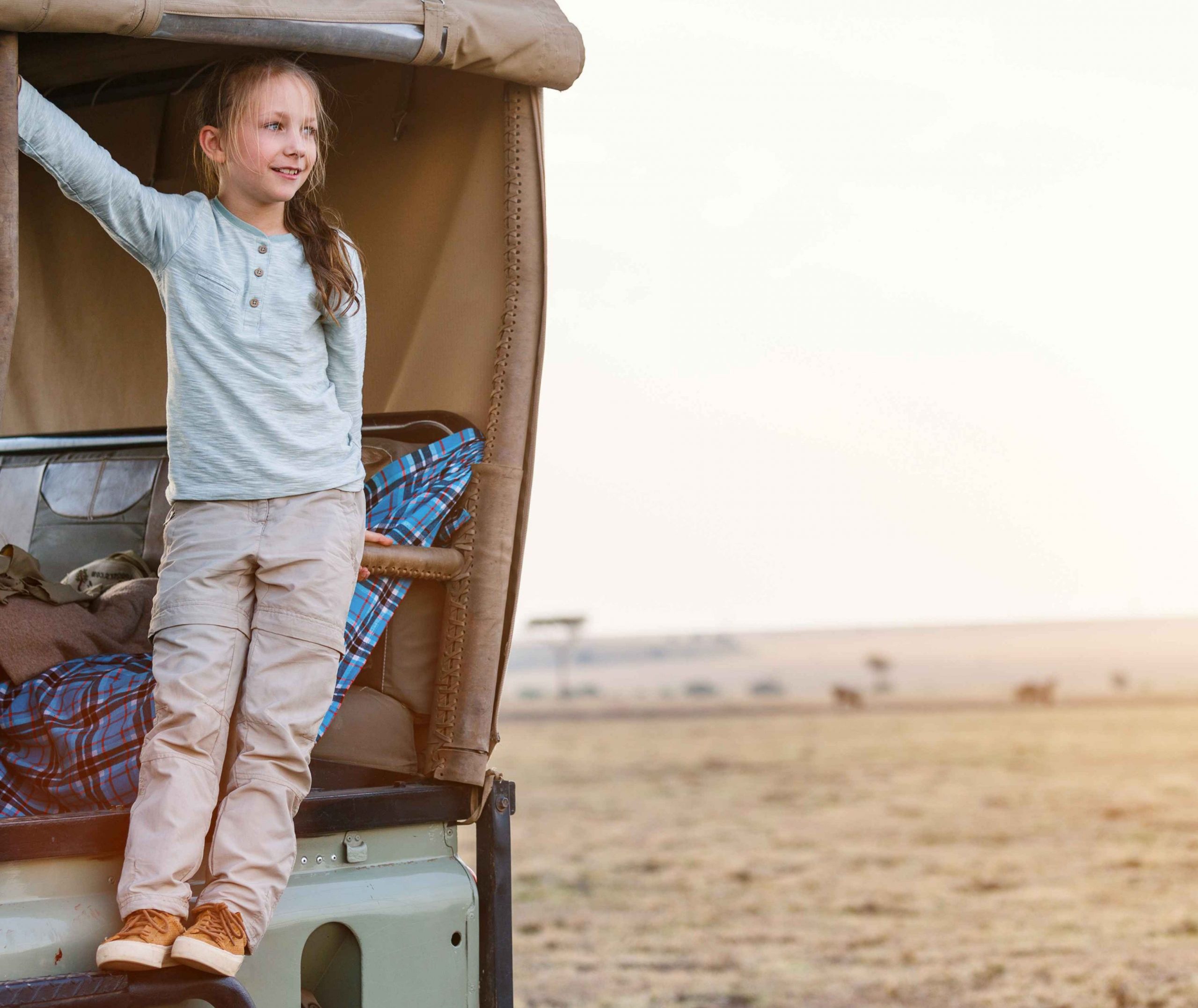 Girl standing on side of safari vehicle