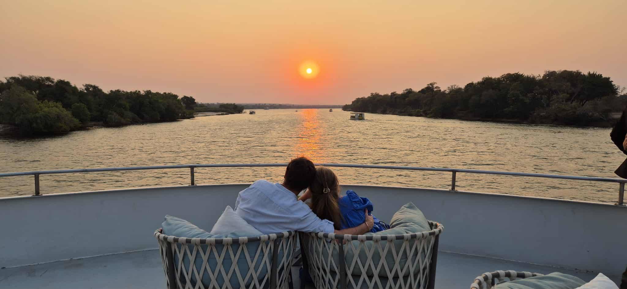 Man and woman in romantic shot on boat safari at sunset