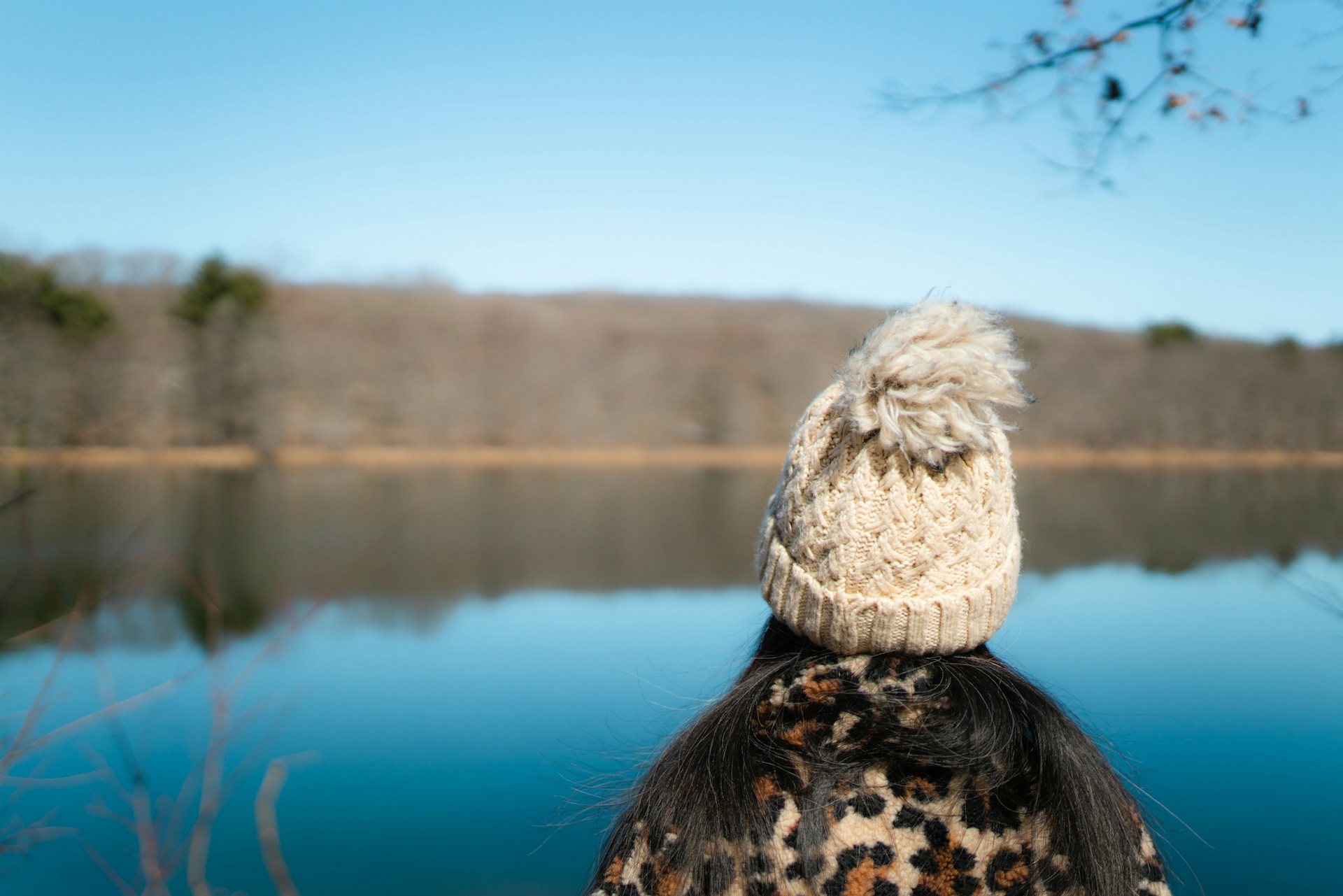 Woman in white beanie overlooking lake
