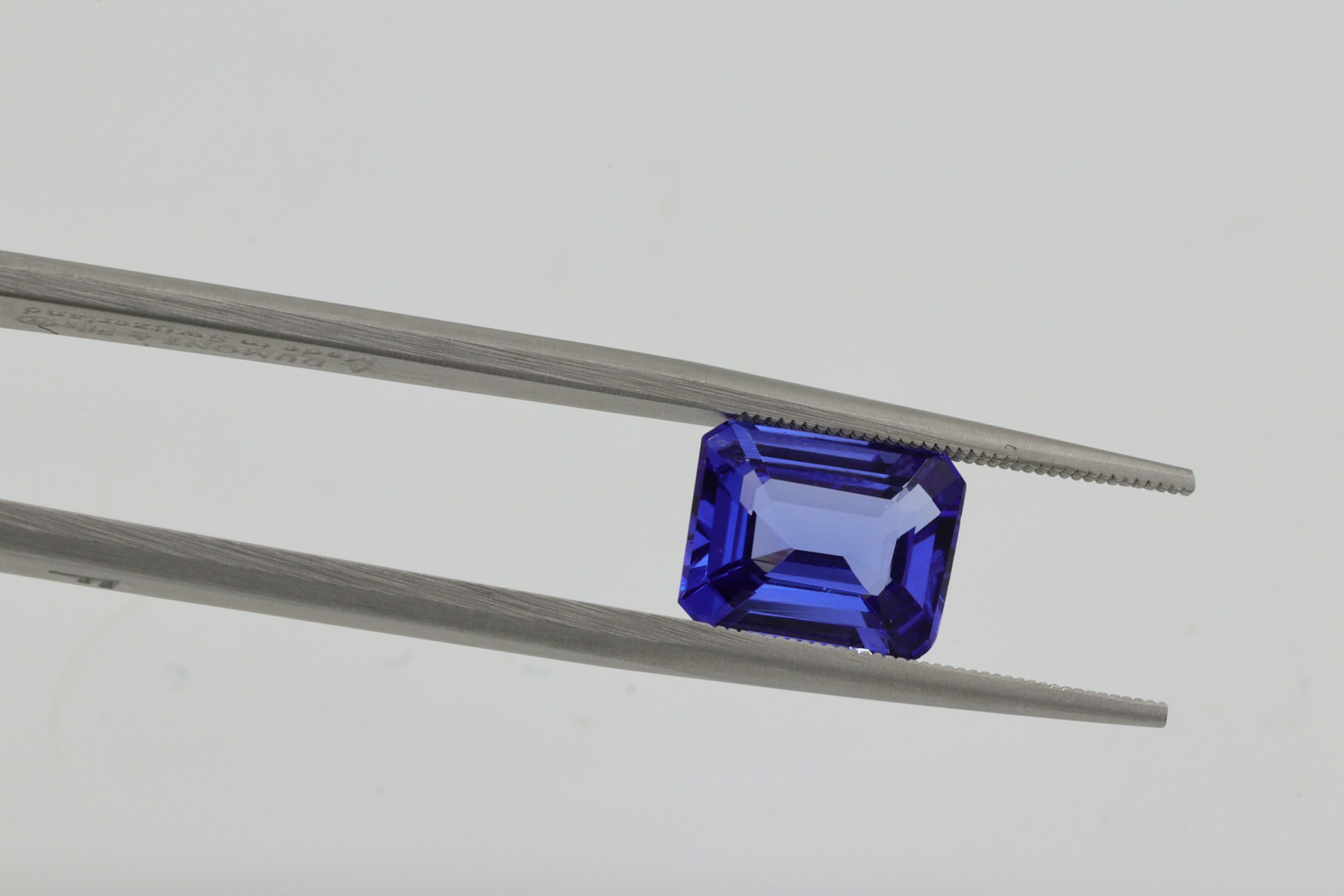 Tanzanite gemstone being held by tweezers