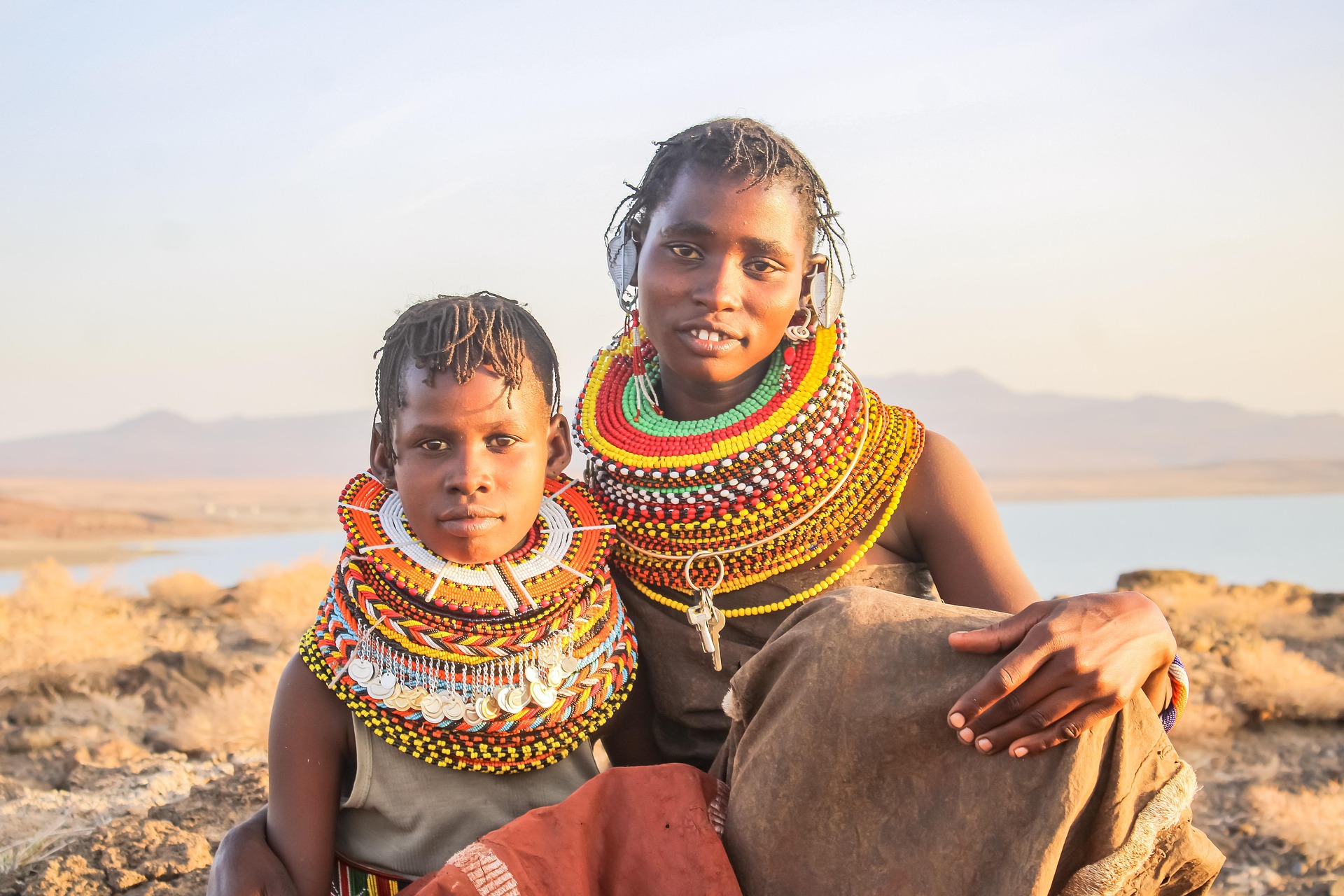 Two Turkana children looking at camera in front of Lake Turkana, Kenya