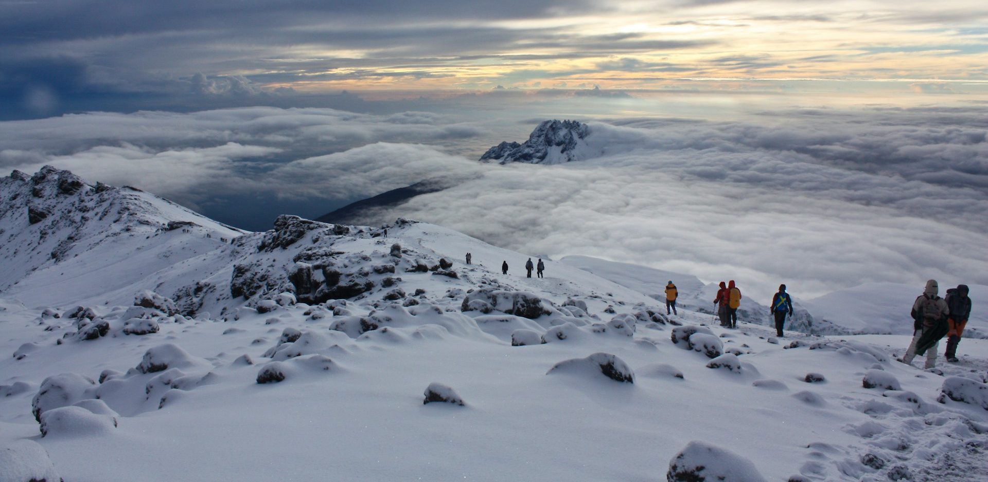 Trekkers walking through snow at mountain summit in Mount Kilimanjaro National Park