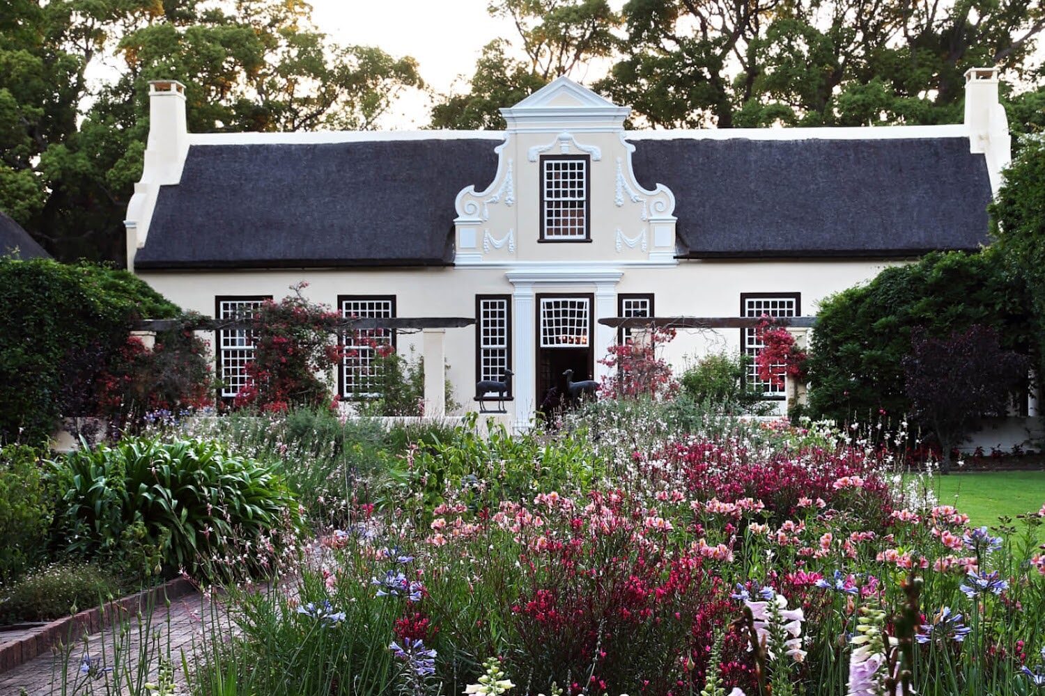 Colorful flowers bloom in the garden of a Cape Dutch house at Vergelegen Wine Estate