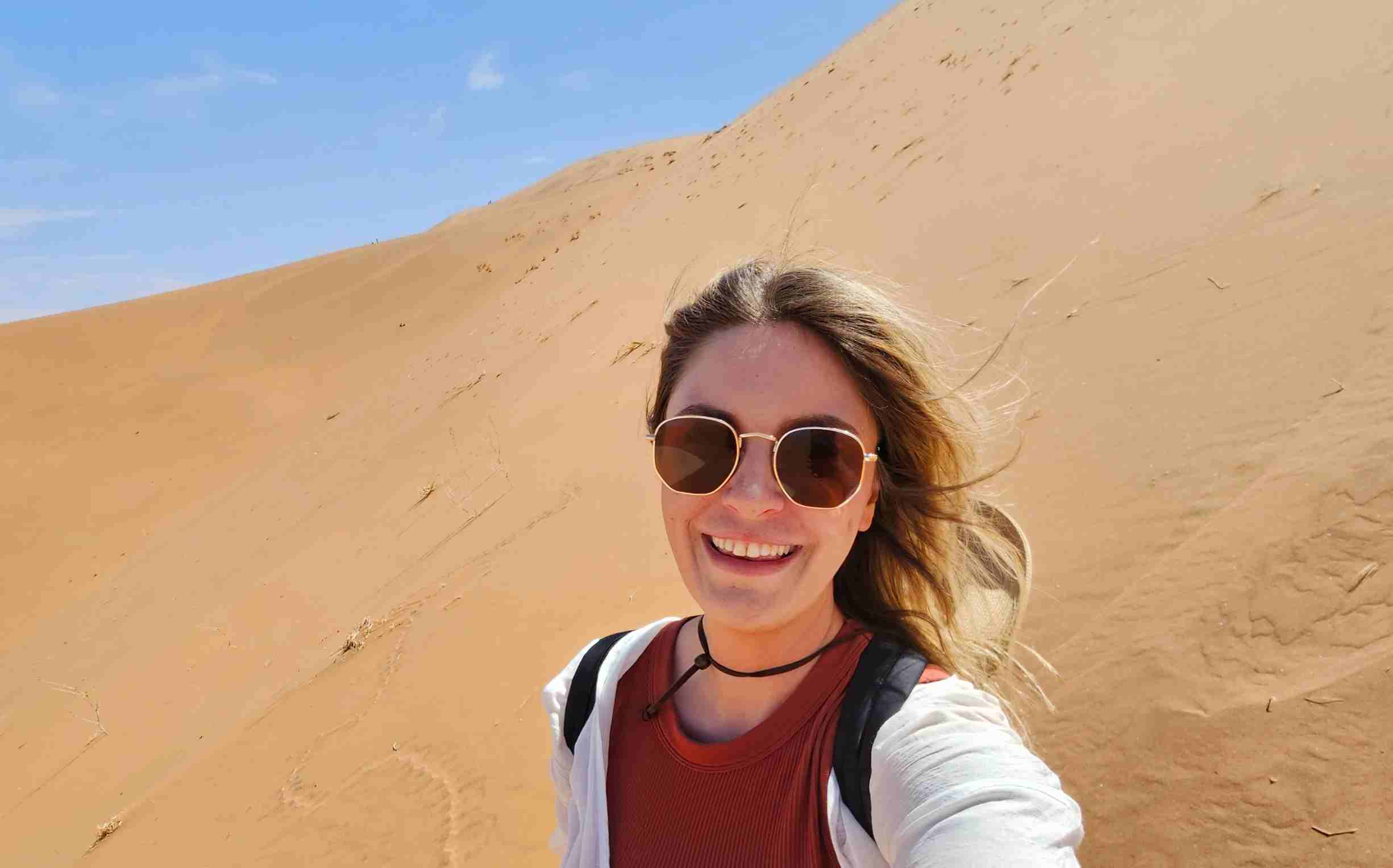 female walking down a dune in namibia