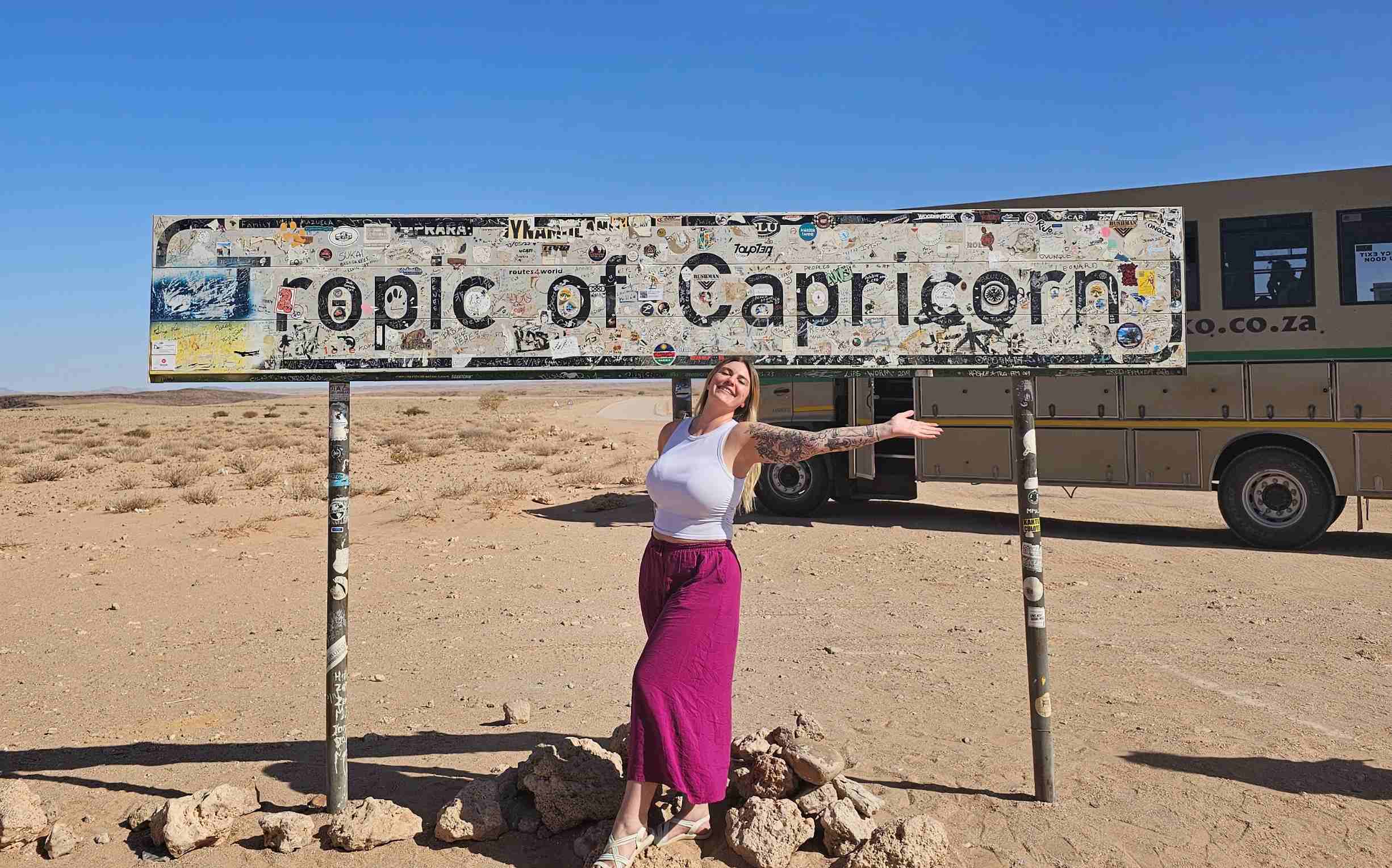 solo female traveller standing at the tropic of capricorn in namibia