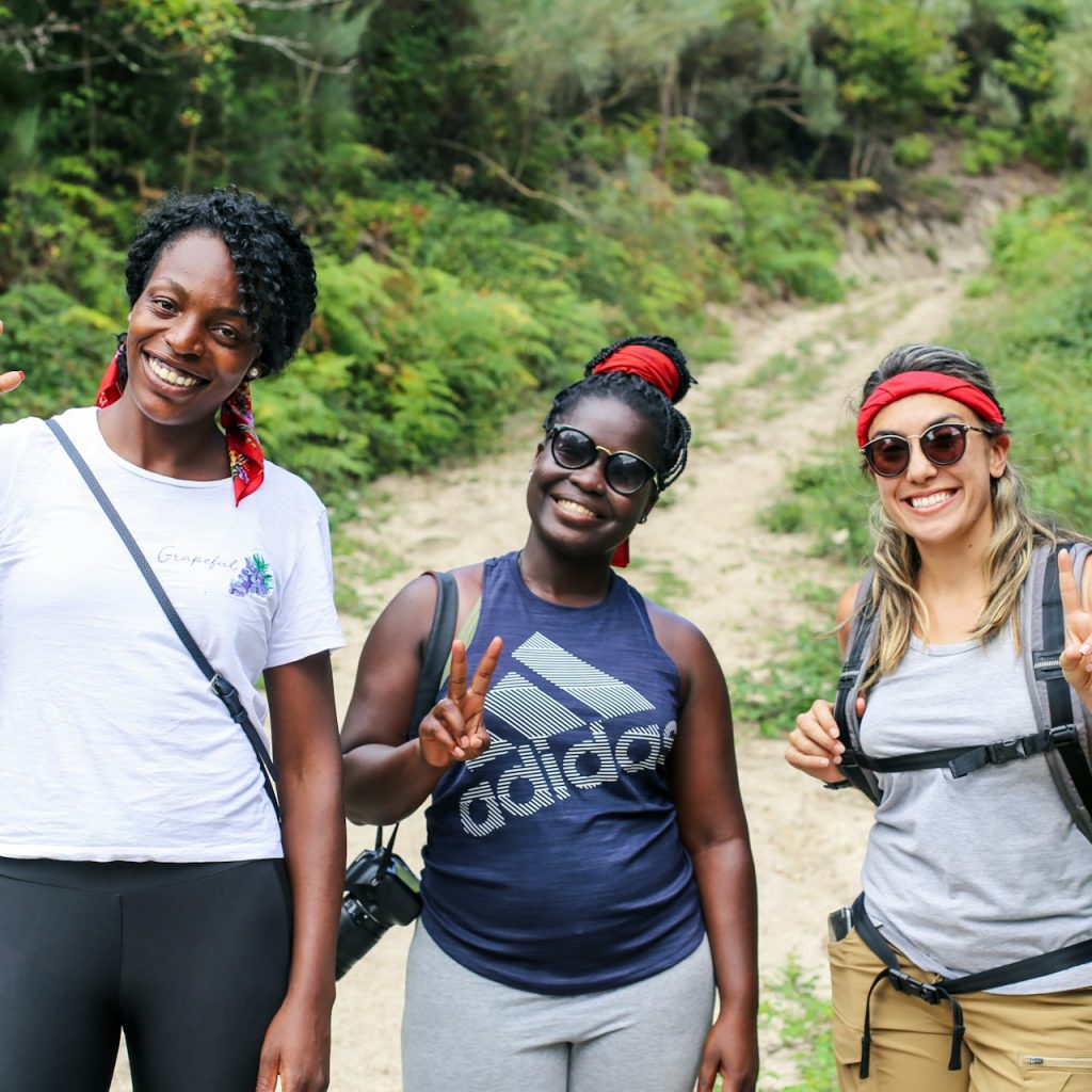 Three ladies on a hike and smiling at the camera, group travel