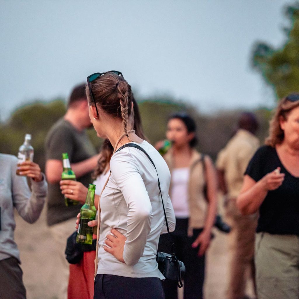 Overlanding tour group having beers in evening