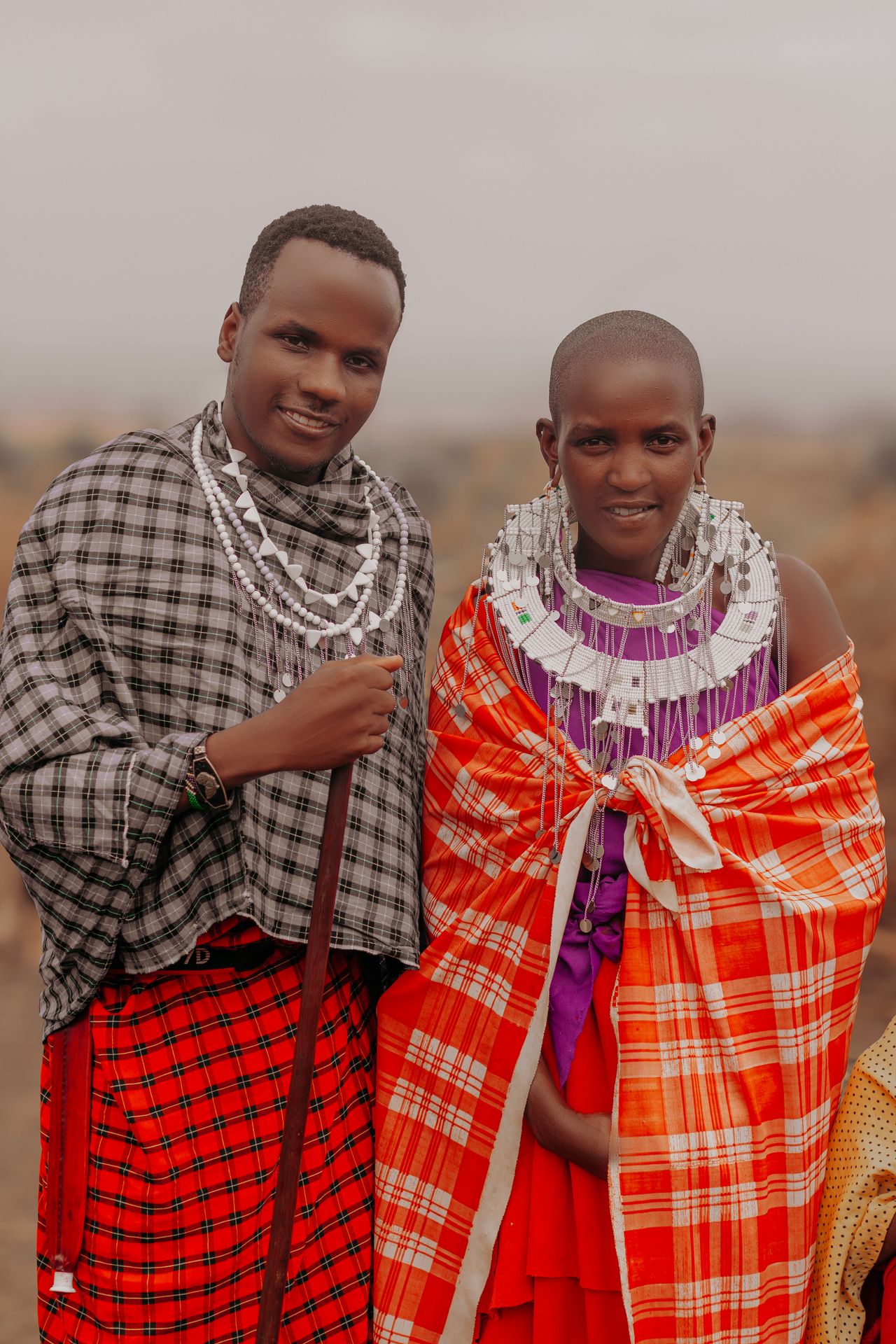 two young maasai men in traditional clothing and jewelry