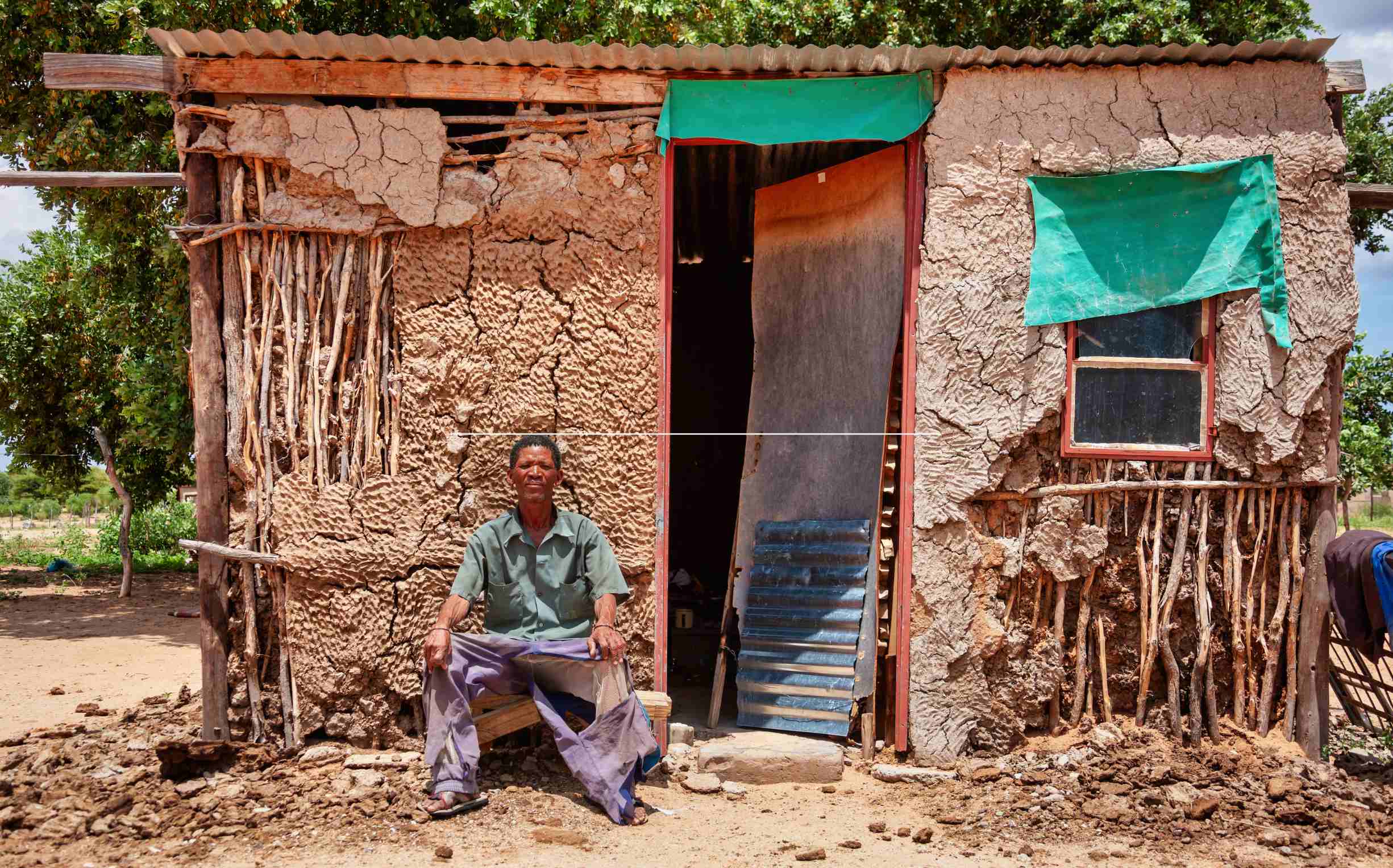 an old bushman man from central kalahari village in new xade in botswana in front of his home